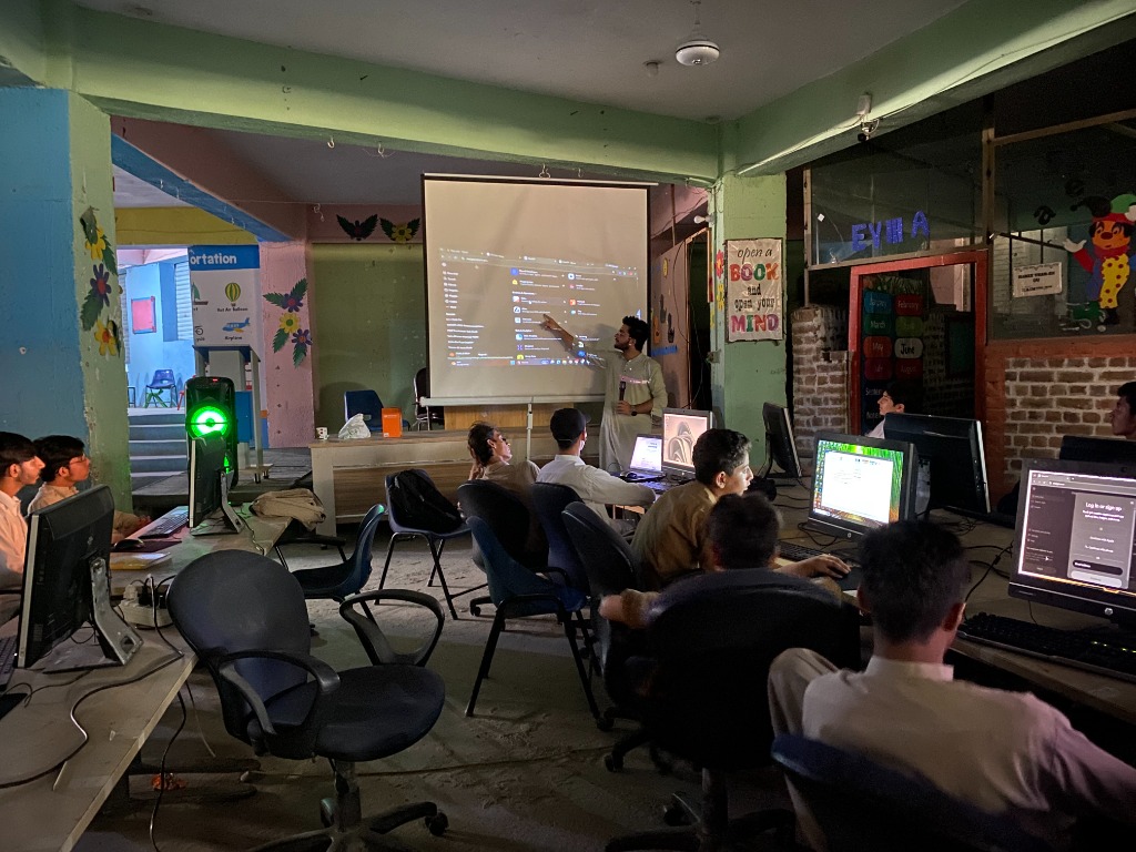 AIMS instructor and students collaborating on digital technology and coding workshop